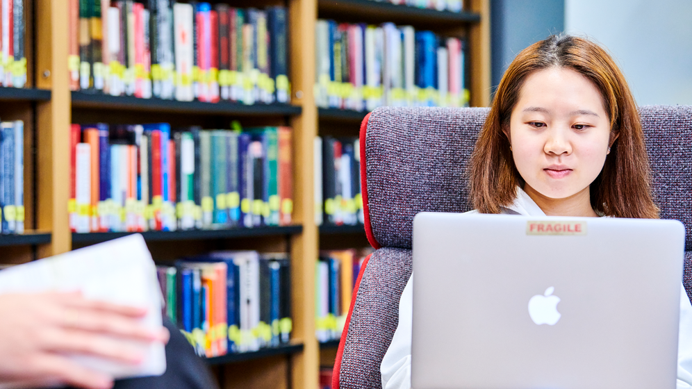 Student working on laptop in library