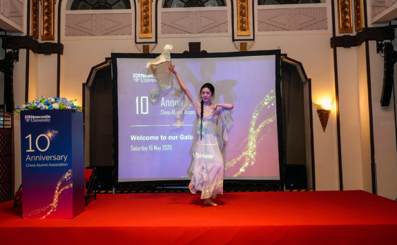Aluma Yingjun Chen performing a traditional Chinese dance on stage before dinner