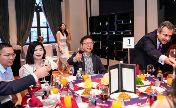 A group of alumni clinking glasses in celebration around a table