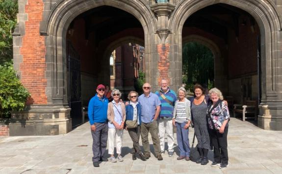 A group of alumni posing in front of the Arches