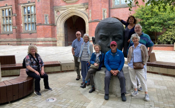A group of alumni sat next to one of the Generation sculptures on campus