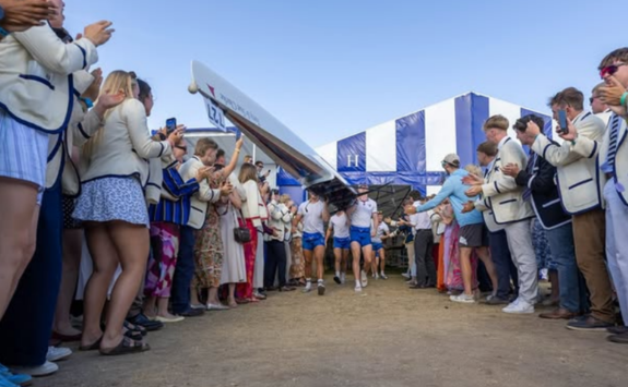 Team Newcastle carry out their boat to a crowd wearing Blue Star blazers applauding. Image credit JRN HQ.