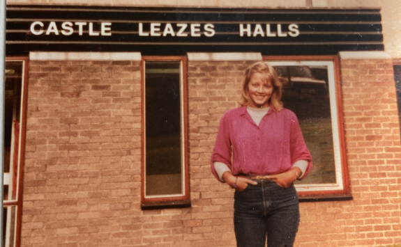 Nickie stood smiling outside of Castle Leazes Halls in the 1980s