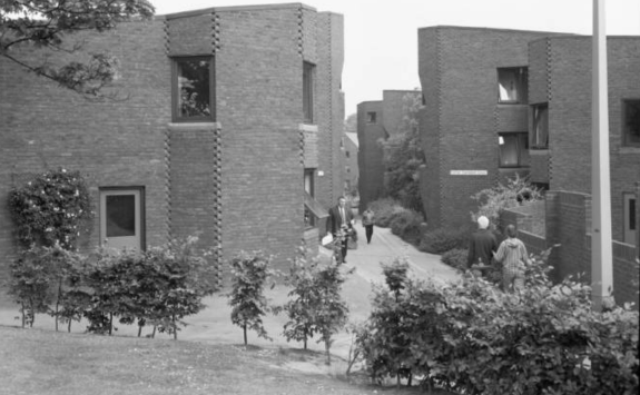 A black and white photograph showing Richardson Road accommodation in 1978. Young trees are in the foreground with people walking along the paths between the accommodation blocks.