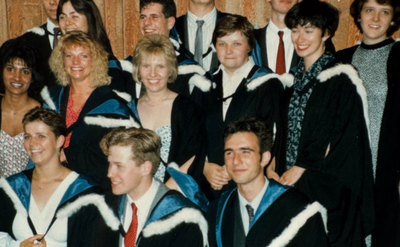 Sam and her classmates smiling on graduation day