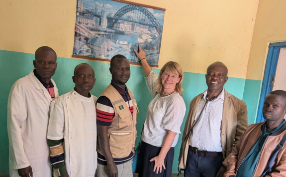 Karen pointing to a photo of the Tyne Bridge on a hospital wall in Katoka DRC