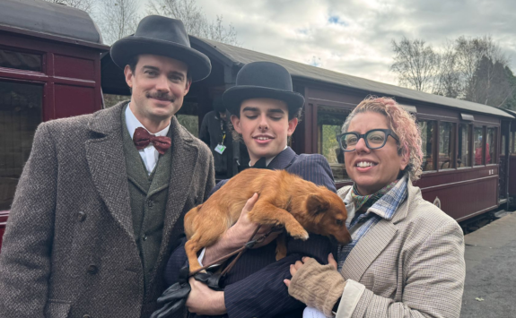 Tina with Jack Whitehall and another actor on a train platform. 