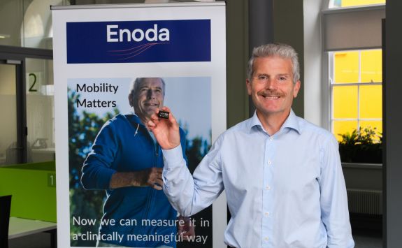 Michael McMahon is the CEO of Enoda. In the picture, Michael is looking to camera and holding a small object. It is one of the Enoda sensors.