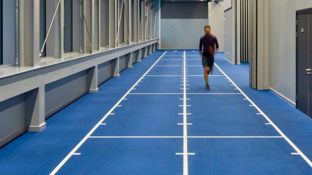 Participant running along an instrumented gait track within Newcastle University's biomechanics and gait laboratory, a specialist facility used to analyse human movement, performance and injury risk.