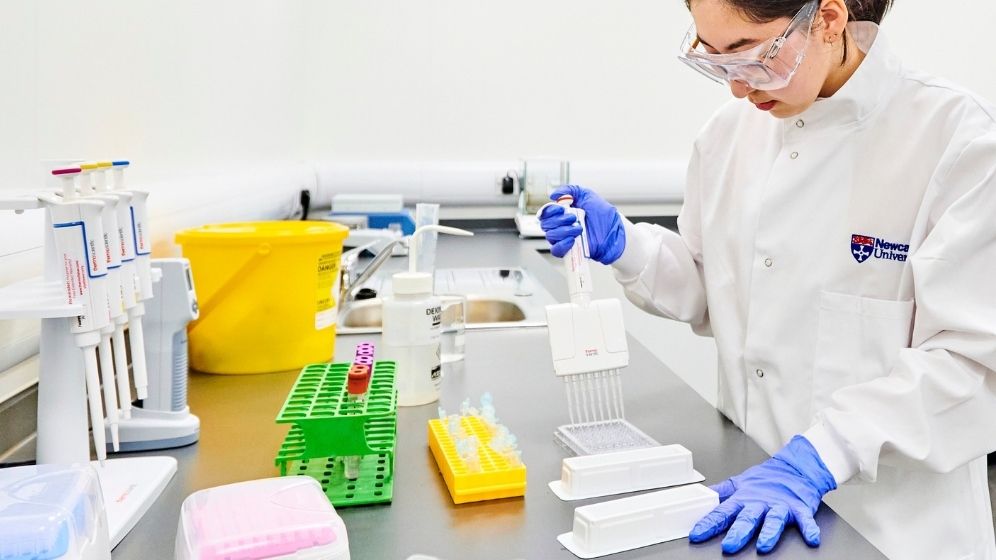 Research laboratory technician preparing biological samples using precision pipetting equipment in a nutrition and health research laboratory.