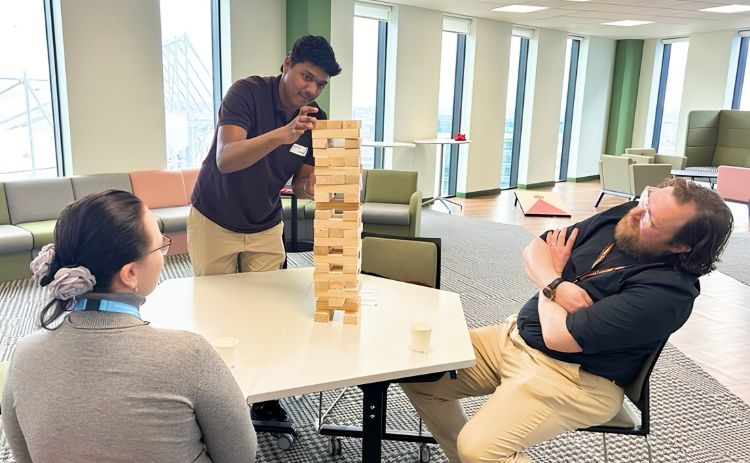 Three alumni enjoy a game of giant Jenga during a Newcastle University Business School alumni community café event