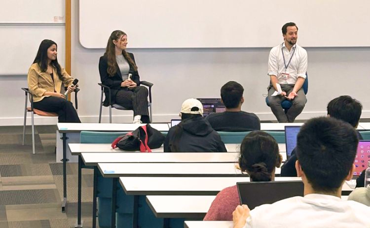A panel discussion featuring Newcastle University Business School alumni takes place in front of an audience of students.