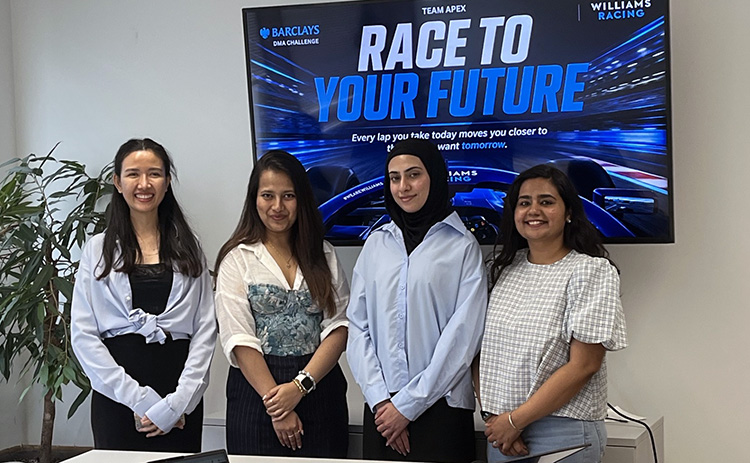 Four students stand together in front of a screen displaying the ‘Race to Your Future’ campaign after winning the 2026 APEX Marketing Challenge.