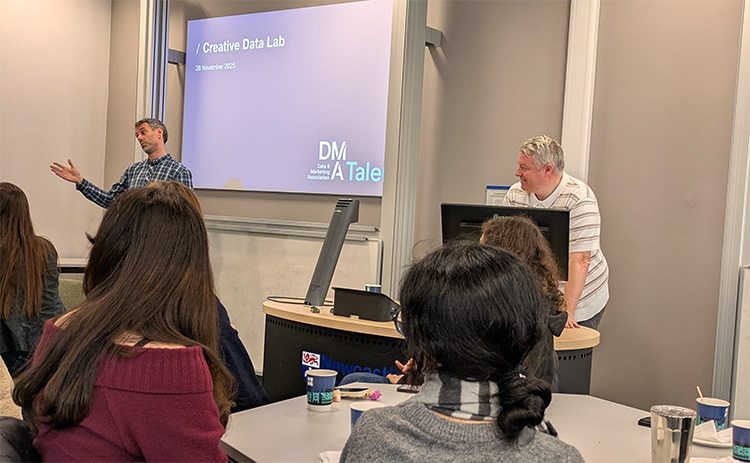 Kirk Dodds and David Hart address students during the DMA Creative Lab, with attendees seated at tables in a workshop-style classroom.