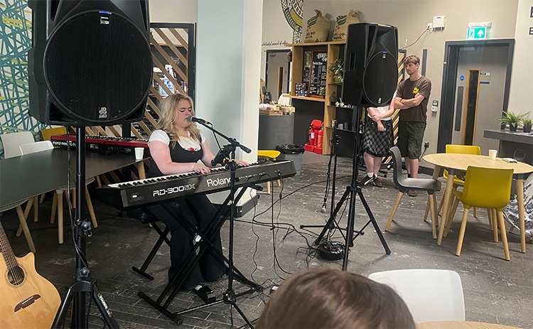 Musician sings and plays keyboard during a live performance at an Economics of Music event at Newcastle University Business School.