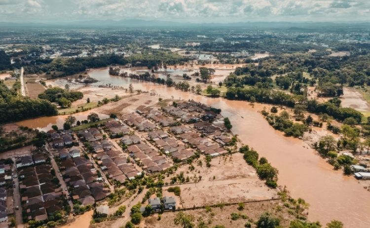 Aerial view of widespread flooding surrounding homes, roads and fields in a residential area.