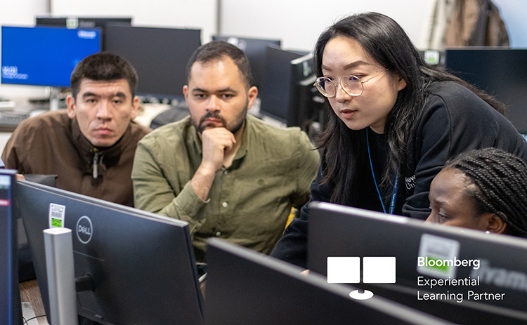 Mengya Wu delivering Bloomberg training to three students at a Bloomberg Terminal