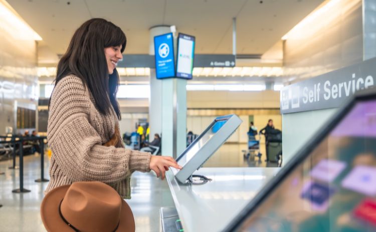 Passenger using a self-service check-in kiosk at an airport.