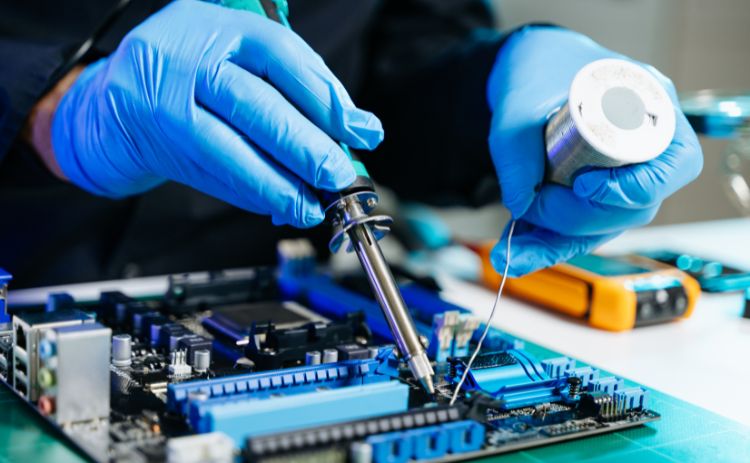 Technician soldering components on a computer circuit board.