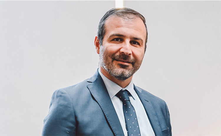 Headshot of Savvas Papagiannidis wearing a blue suit and tie.
