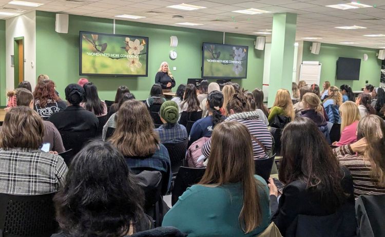 Speaker addresses a large audience at a NUBS Women’s Network event focused on building confidence.