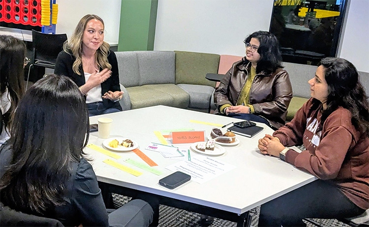 Members of the NUBS Women’s Network take part in a group discussion around a table during a network event.