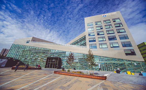 A view of the Urban Sciences Building from the outside courtyard, with clear skies. 