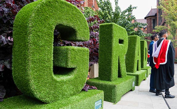 Large grass letters spelling Grad