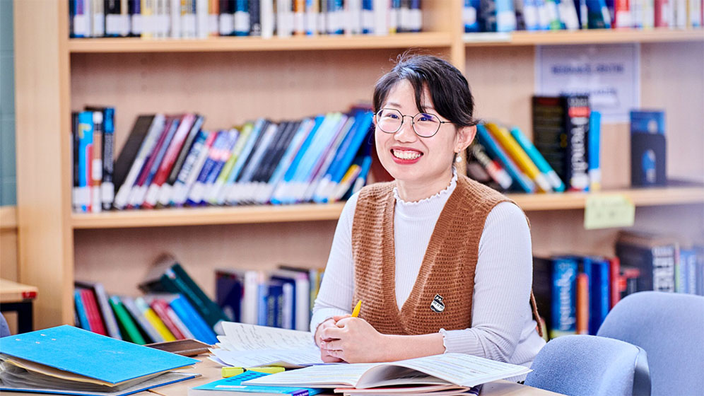 Student in a study room smiling
