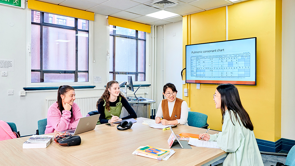 4 students working together at a desk
