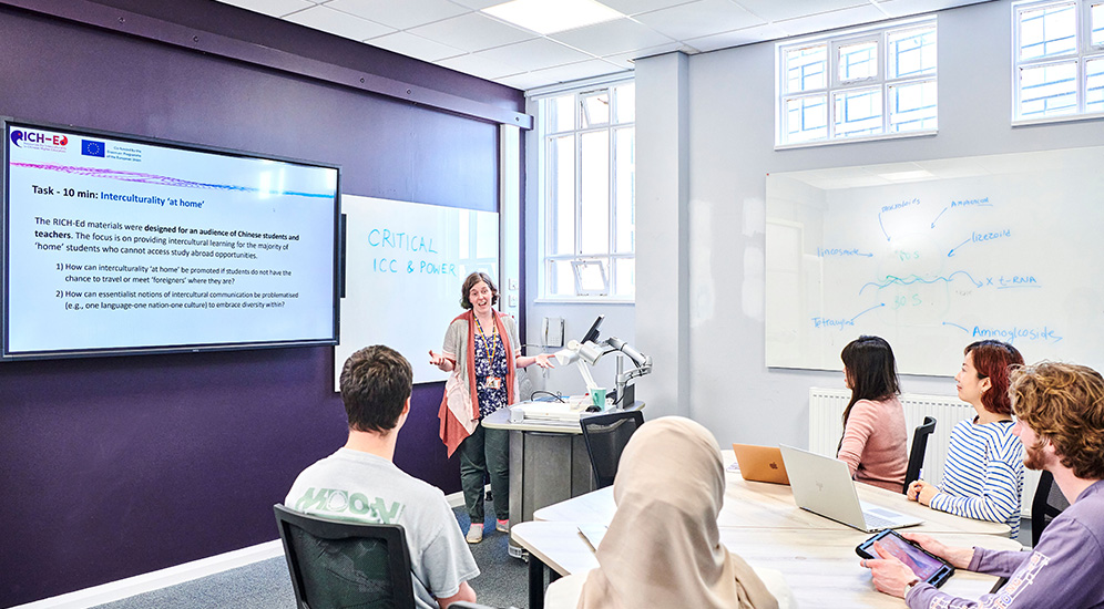 Students working in a seminar room with a lecturer