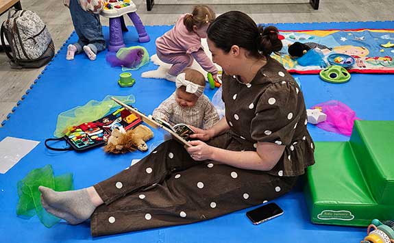 A mum reads to her baby during a session at Babyzone Grimsby