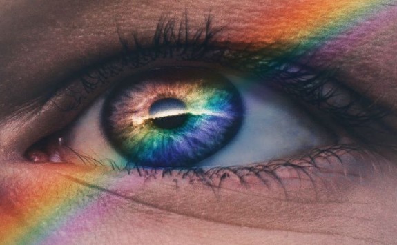 a close-up of an eye with a rainbow reflection