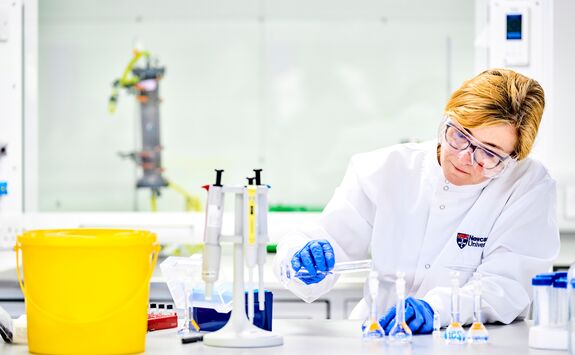 A woman in a labcoat working in our Chemical Engineering and Advanced Materials lab.