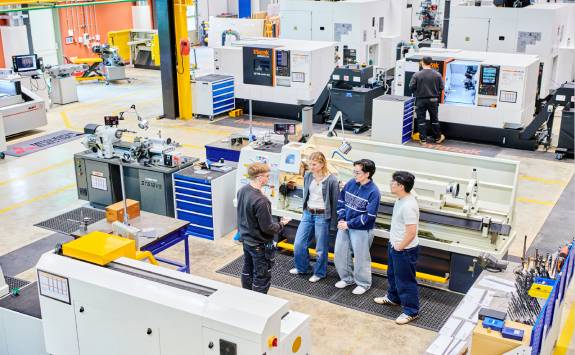A group of students gathered around a project in the lab