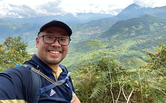 Dr Meng Ren selfie with mountains in the background 