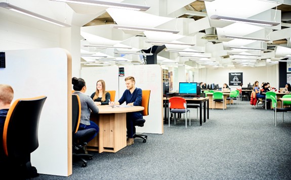 students working at desks with YourSpace Collaborative study signage in the background