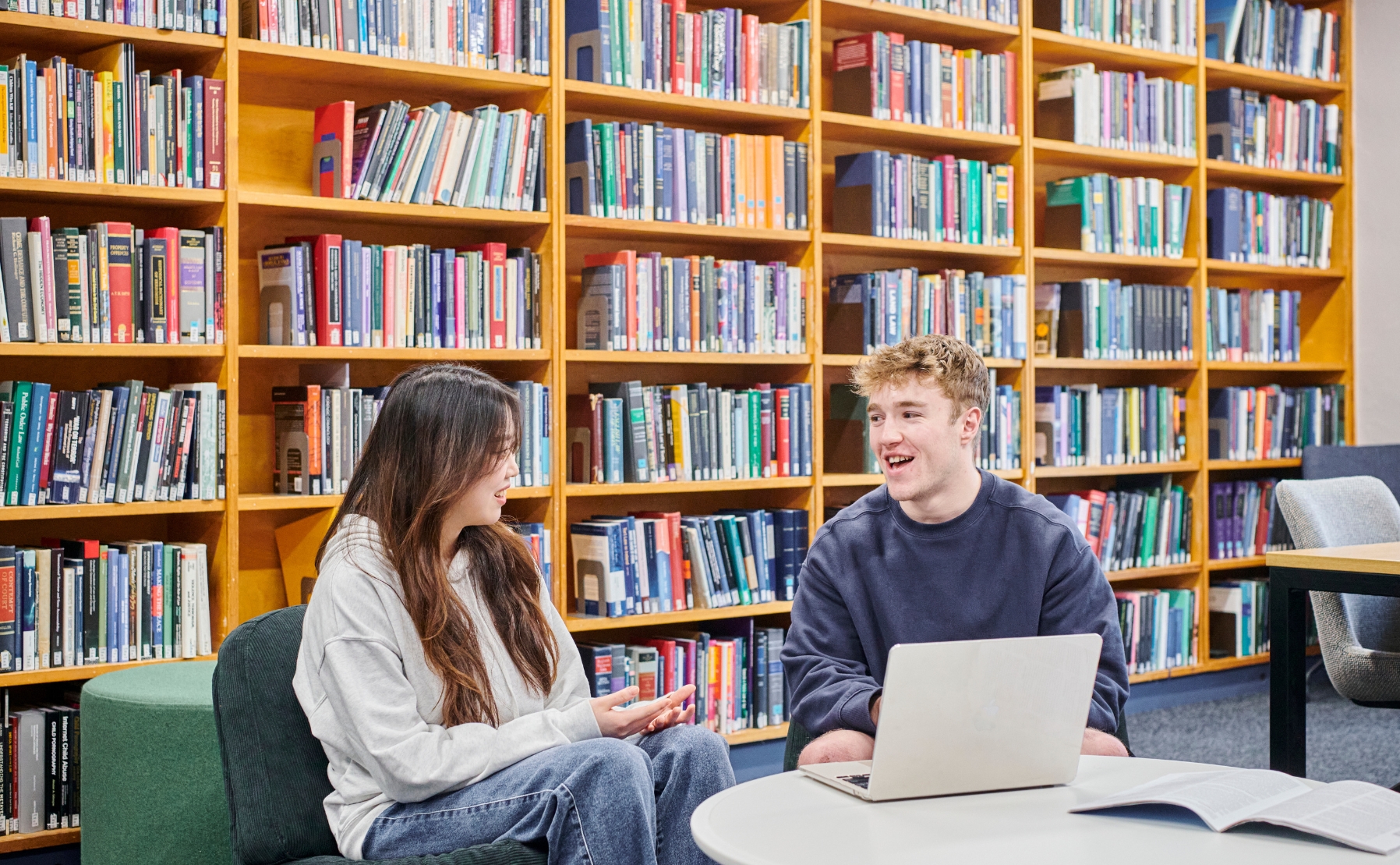 Two students talking in a library