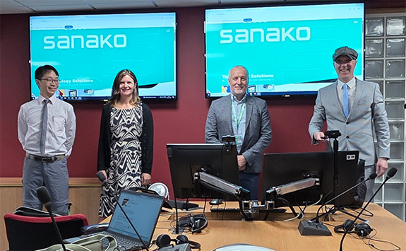 Colleagues standing in front  of Sanako screens