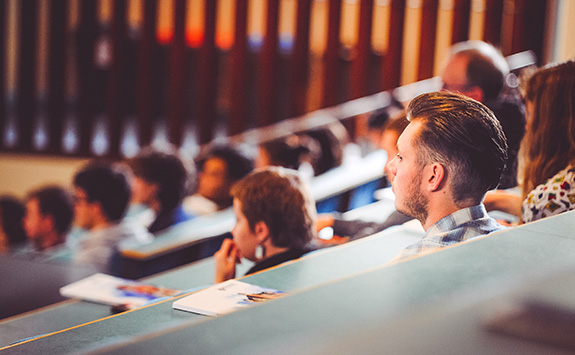 Students sitting in a lecture theatre during a talk. 