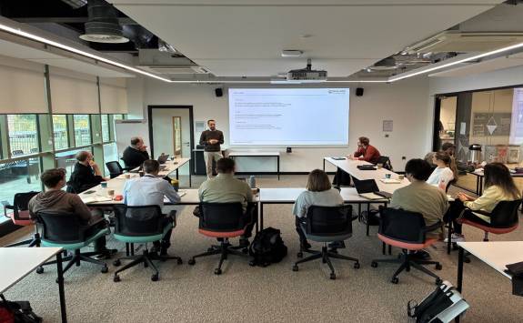 A group of people sat watching a presentation at the Mobility and Transport Early Career Event.