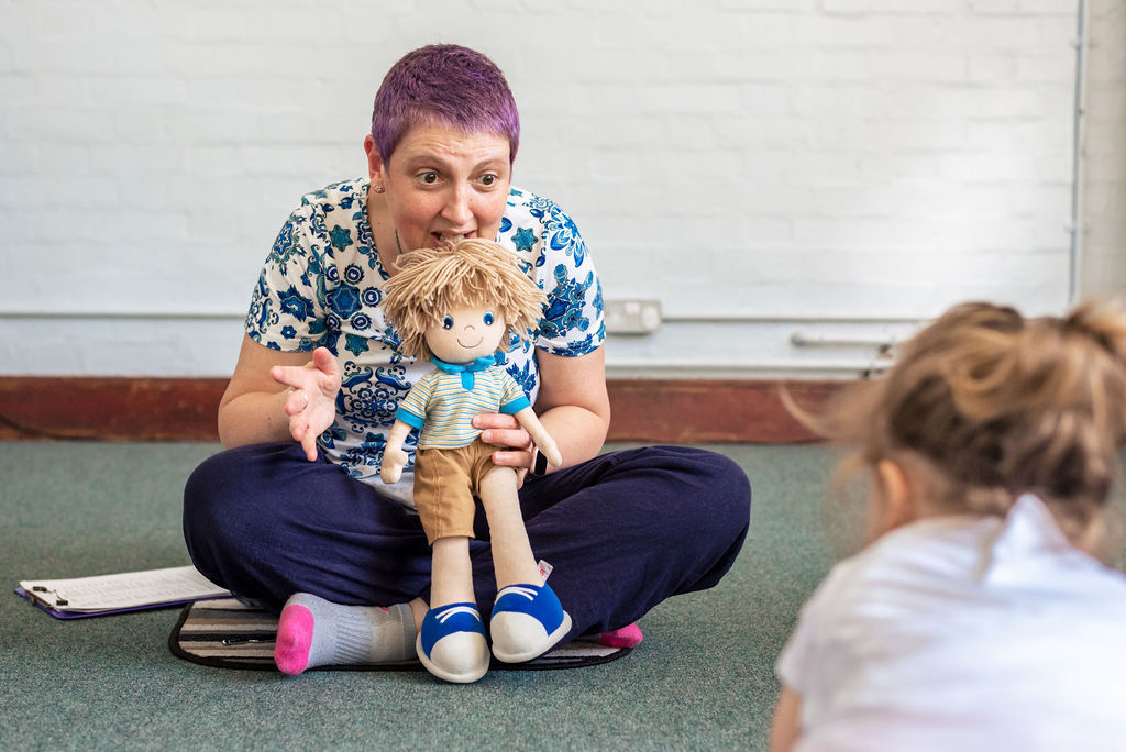 Janey- Music PGR- at work with a doll educating children