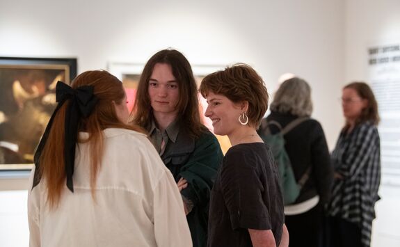 student arranging work of art in gallery