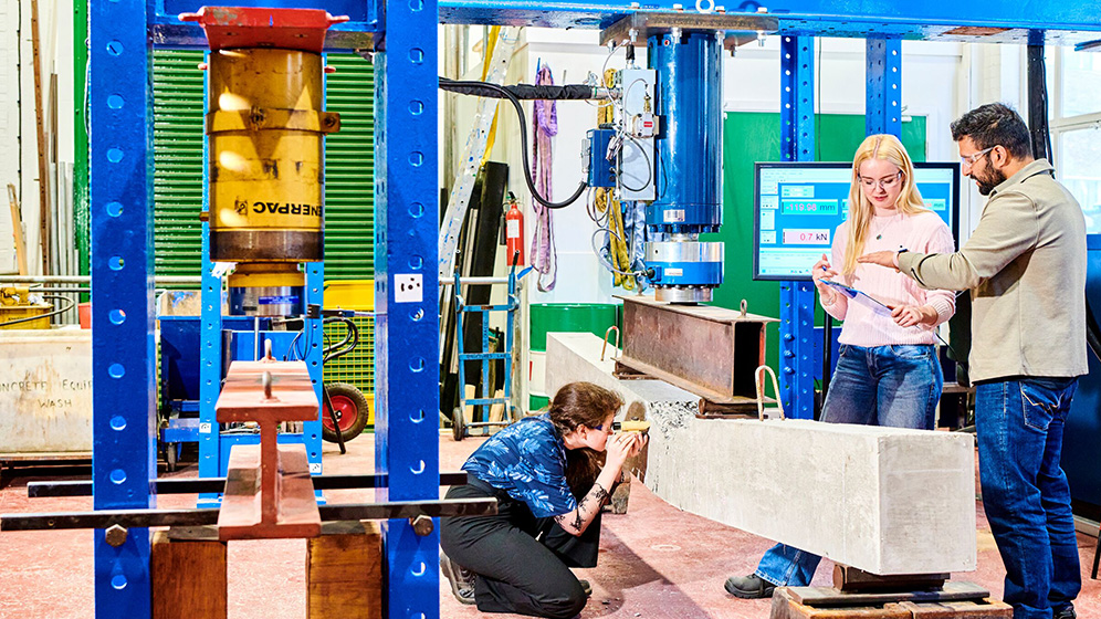 Two students and a staff member working in a laboratory.