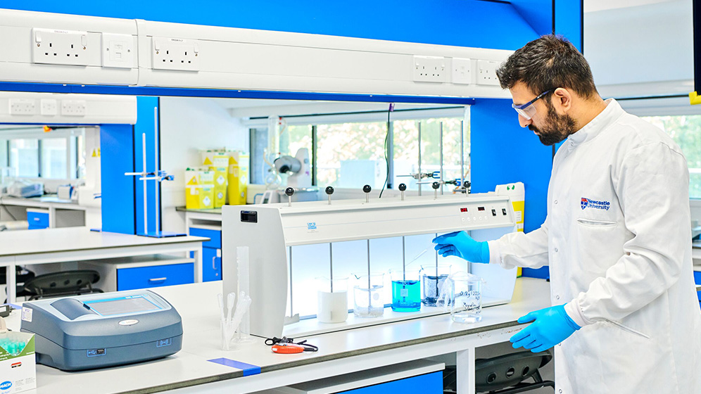 A staff member examining a wave tank.