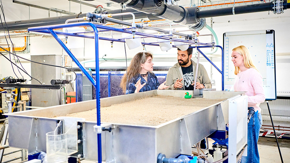 A staff member in a lab coat mixing several liquids in a controlled laboratory.