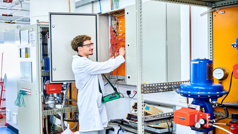 A student testing an electrical distribution board.
