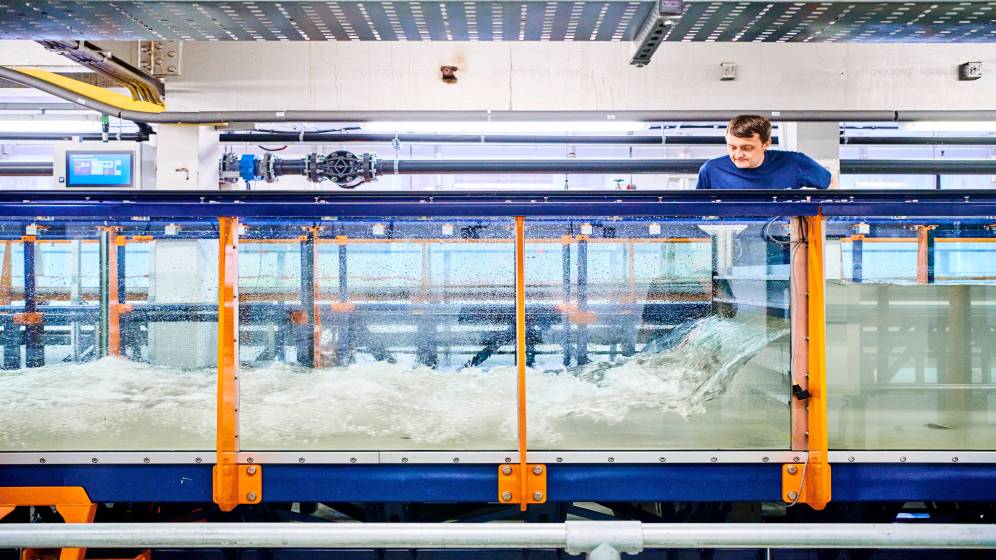 A staff member examining a wave tank.