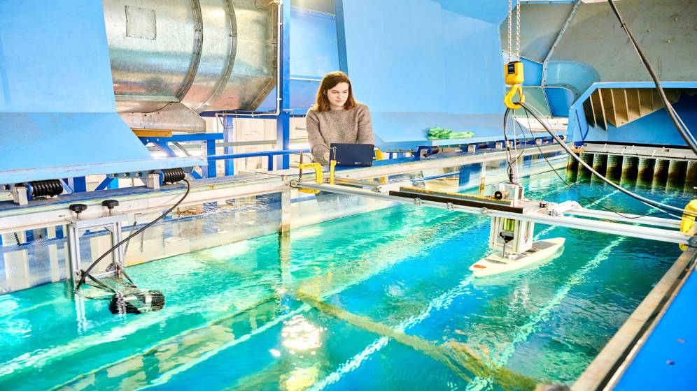 A student stood behind a marine testing tank.